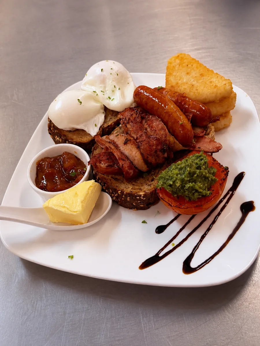 Breakfast plate with poached eggs, sausages, toast and roasted tomato